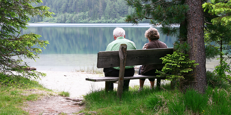 Couple sitting on bench with lakeview