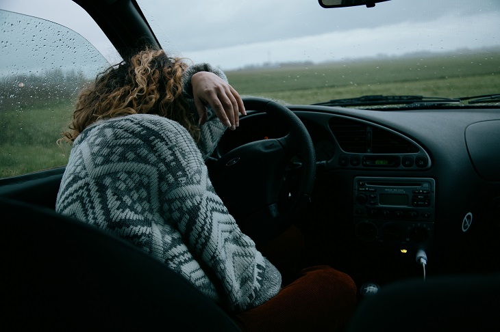 woman upset behind the wheel in car