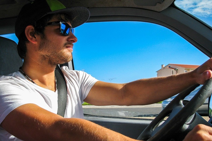 man driving with sunglasses on during summer