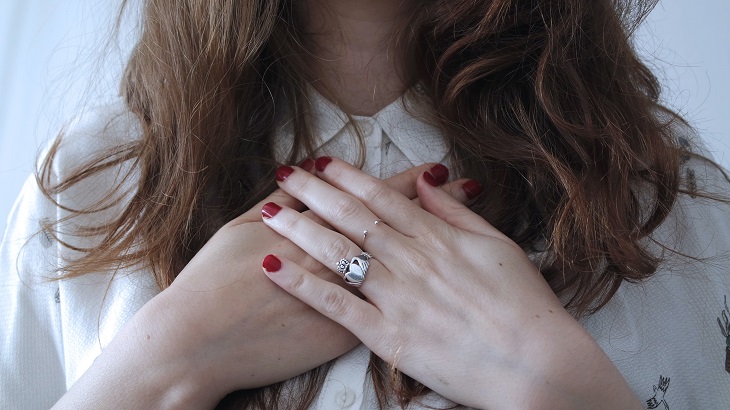 person holding hands to chest