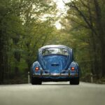 vw beetle car driving through forest